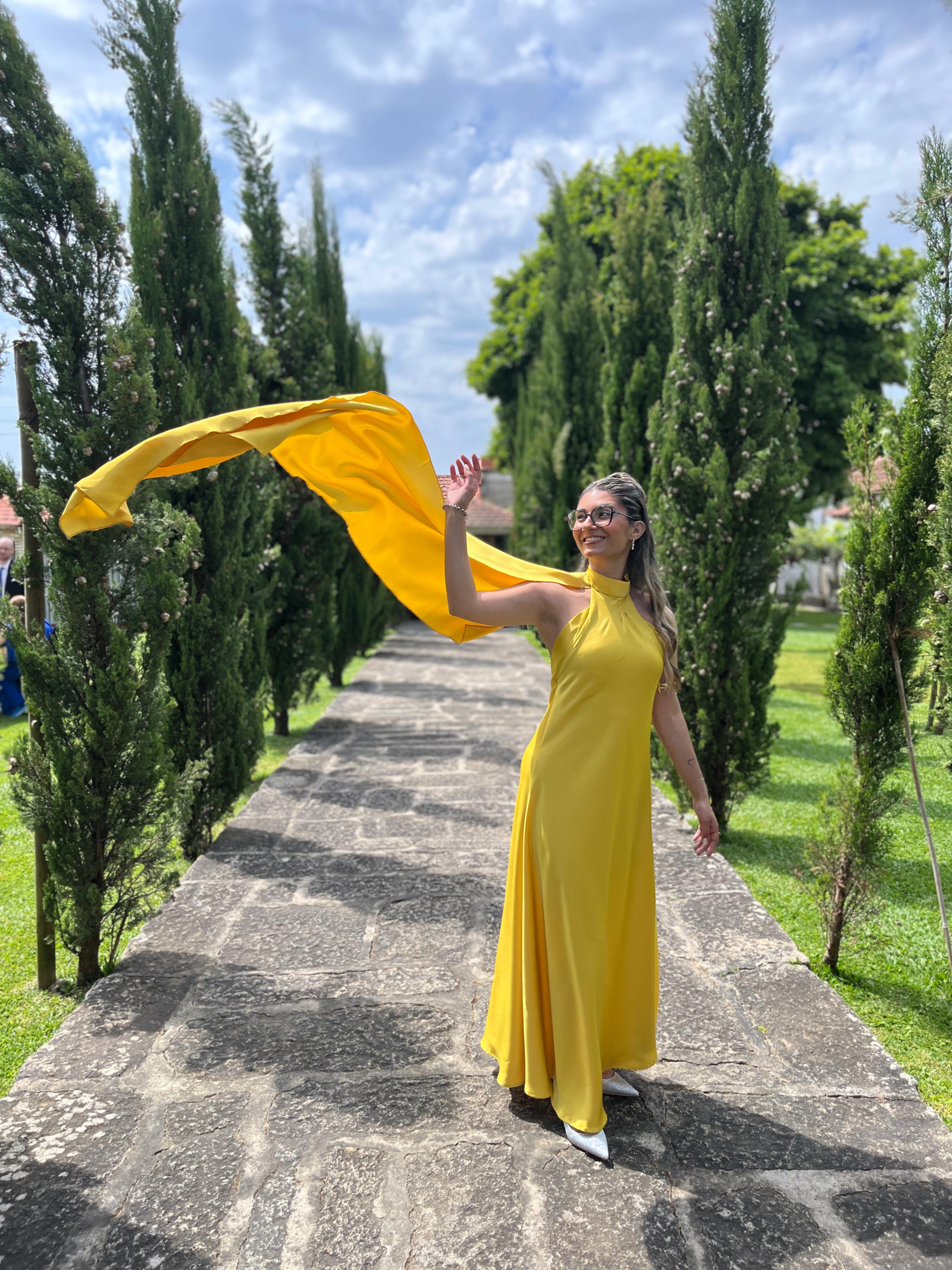 Vestido amarelo fluído com capa ao vento